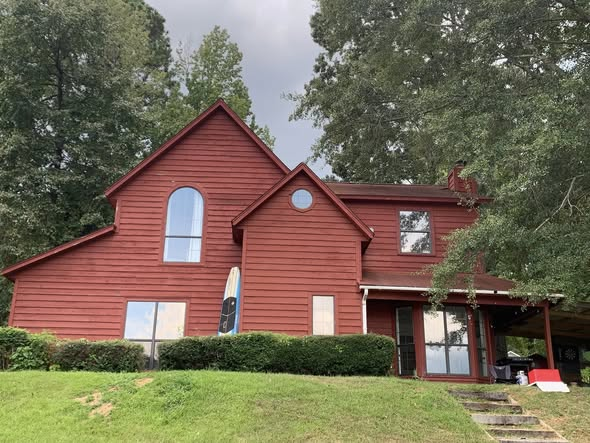 Two-story wood-sided home painted deep red